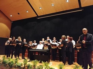 Ramón Lorente, director de la Coral, y los cantores de la Coral saludando al público