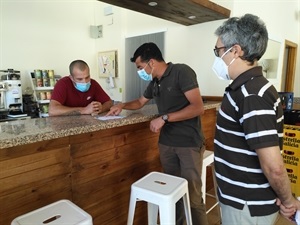 Miguel A. Ivorra, concejal de Urbanismo mostrando a uno de los hosteleros de La Nucía el folleto informativo